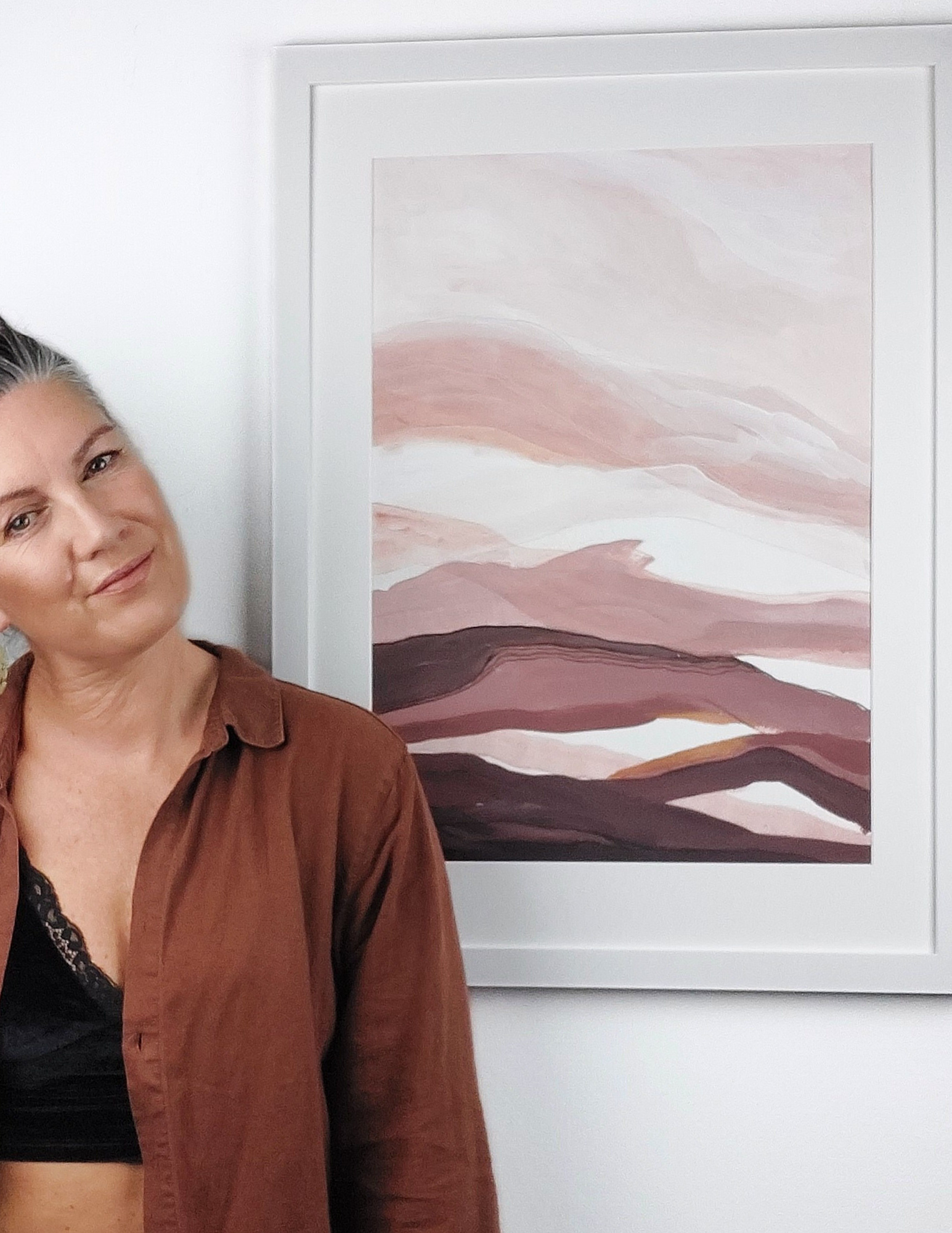 Abstract A2 acrylic landscape artwork by Leanne Aroha Mulder – in terracotta, blush, apricot, clay and mahogany tones  with fine linework and layered earthy textures. Leanne standing next to it.